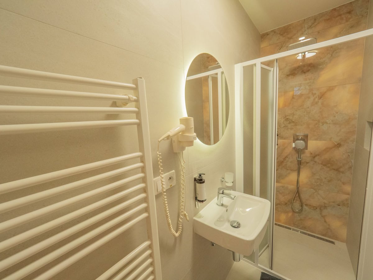 Kúpeľňa so sprchou v apartmáne s jednou spálňou a balkónom
